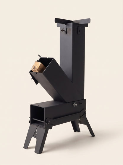 Poêle-fusée portable MASHWIᴹᶜ sur fond clair — acier graphite, chambre en L, sigle flamme